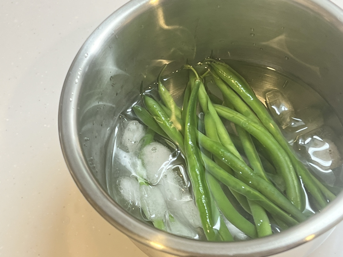 茹でたいんげんを氷水にあげ、水気を拭き取ってからヘタと筋を取り除く