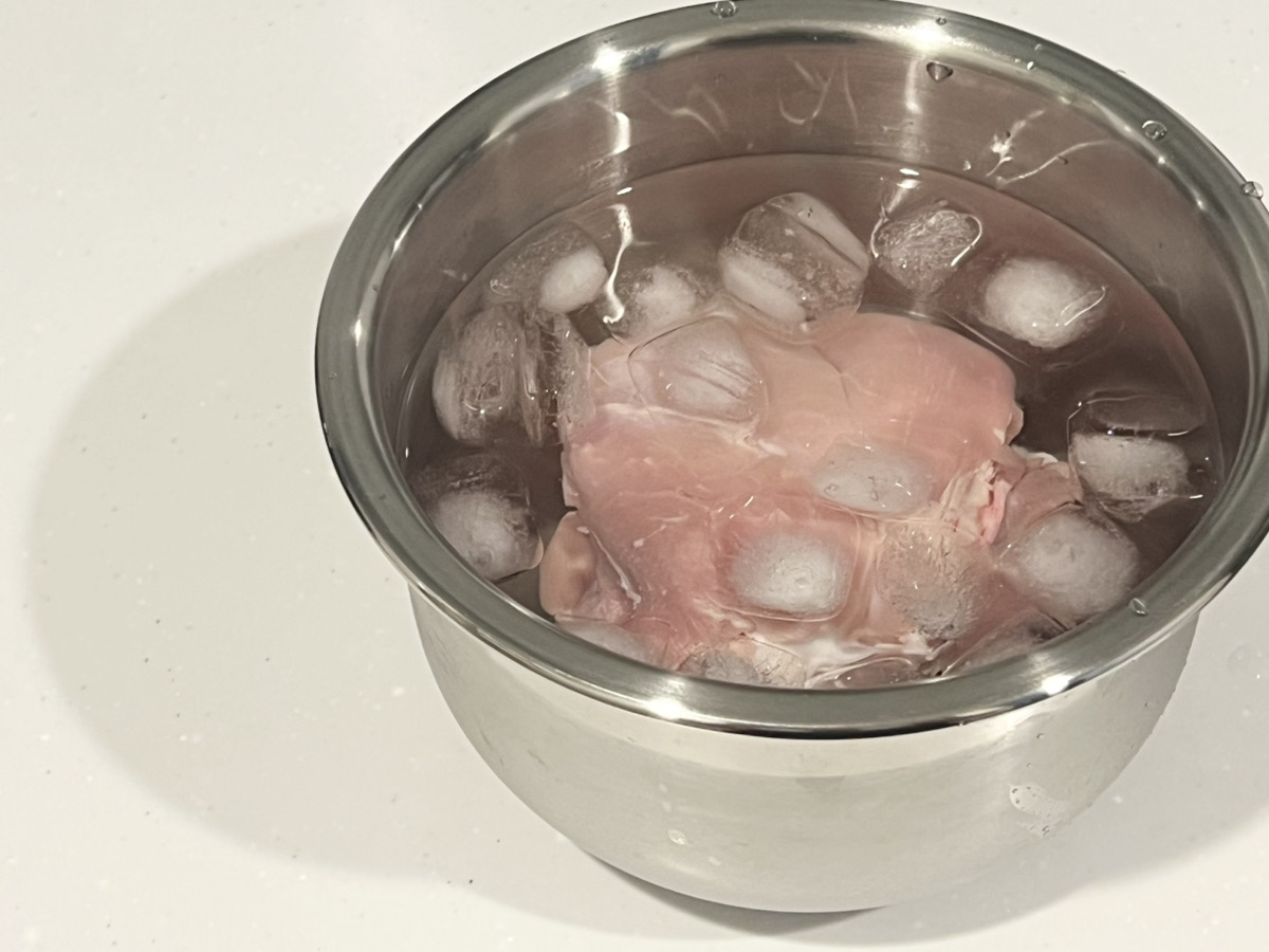 鶏もも肉を氷水にくぐらせる