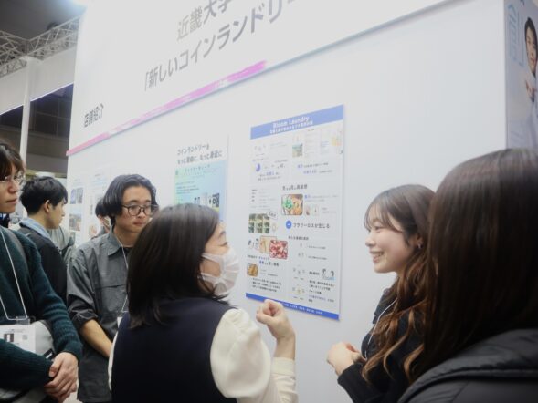 産学連携企画　AQUA×近畿大学経営学部　コインランドリーEXPOにてポスターセッションを実施